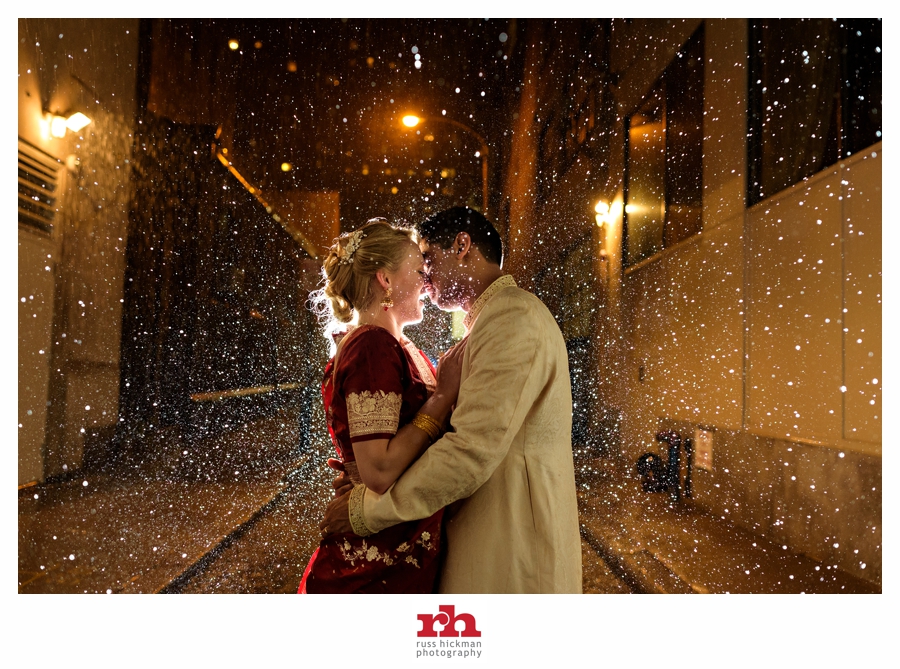 A Fusion Wedding Couple kiss in the rain during thieir Philadelphia wedding at The Racquet Club of Philadelphia.